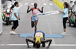 Robert Cheruiyot gives thanks as Alice Timbilili finishes